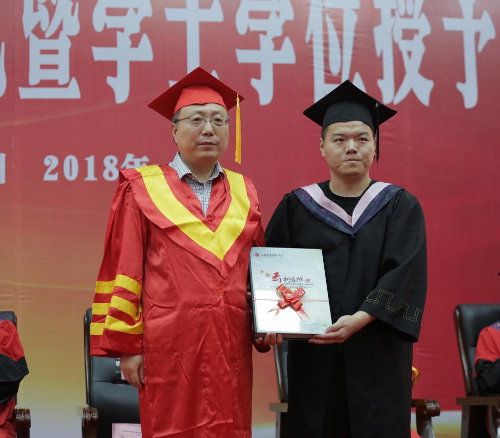 校党委书记穆瑞杰代表学校接受毕业生赠送的纪念册《云树春晖》 m88help